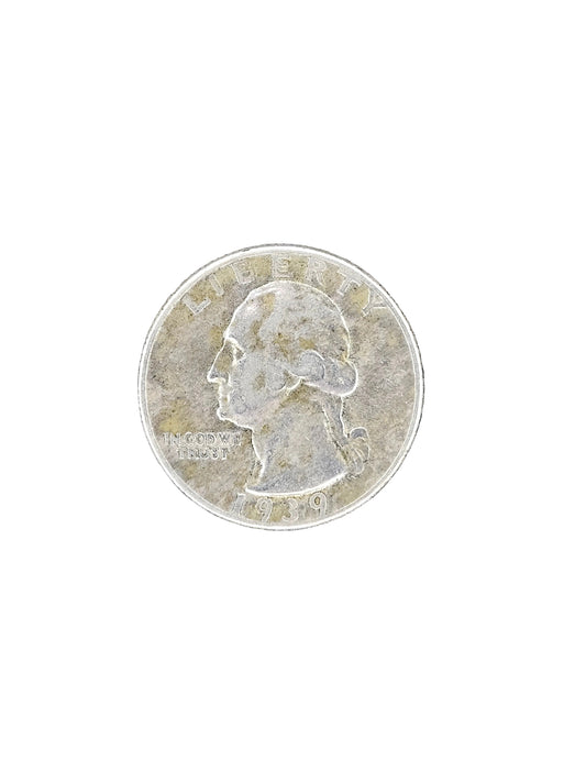 A silver US quarter coin showing the profile of George Washington, placed on a dark, weathered wood surface.