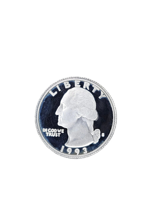 A round silver-colored coin with a profile portrait and the word LIBERTY around the edge, placed on a weathered gray wood surface.